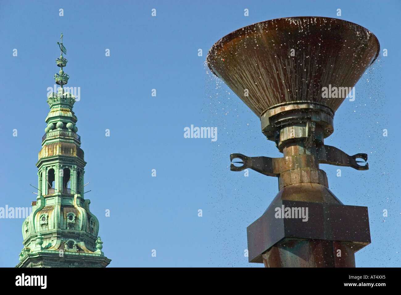 Water fountain at the Royal Library Garden, behind the spire of the Parliamen, Christiansborg. Copenhagen, Denmark Stock Photo