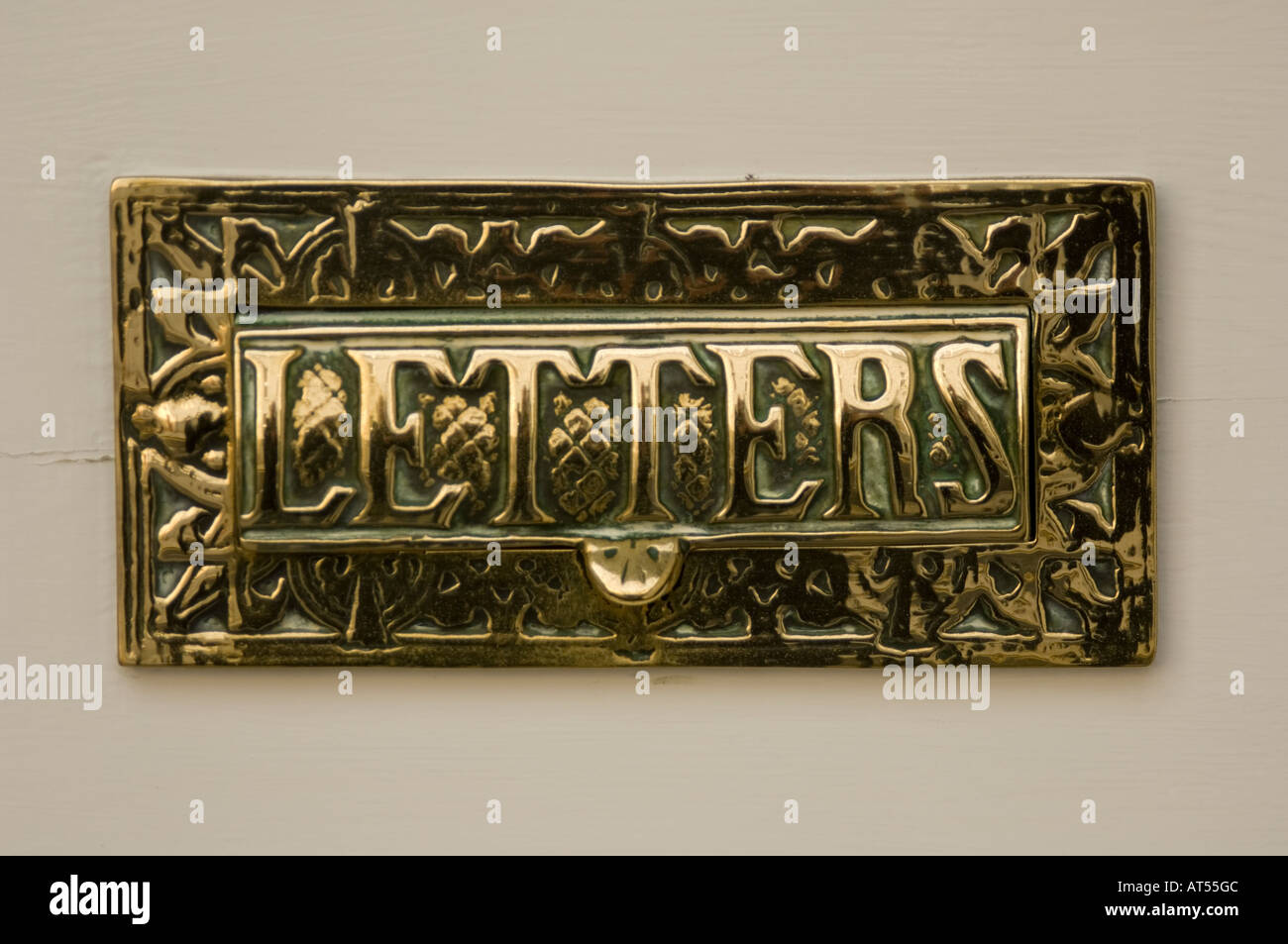ornate brass letter box on door with the word 