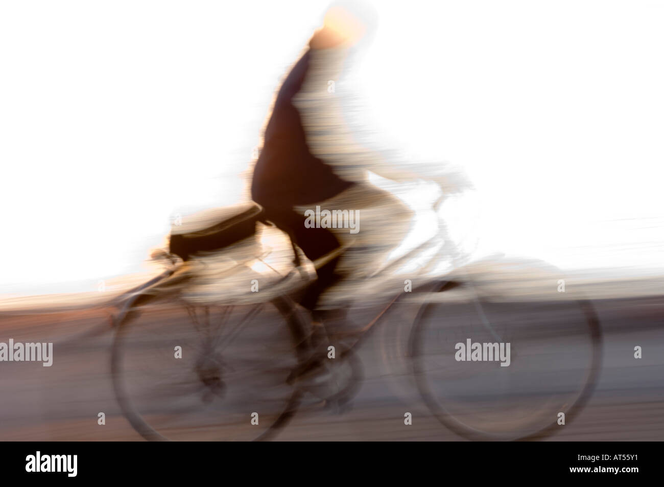 blurred cyclist moving left to right across the frame Stock Photo