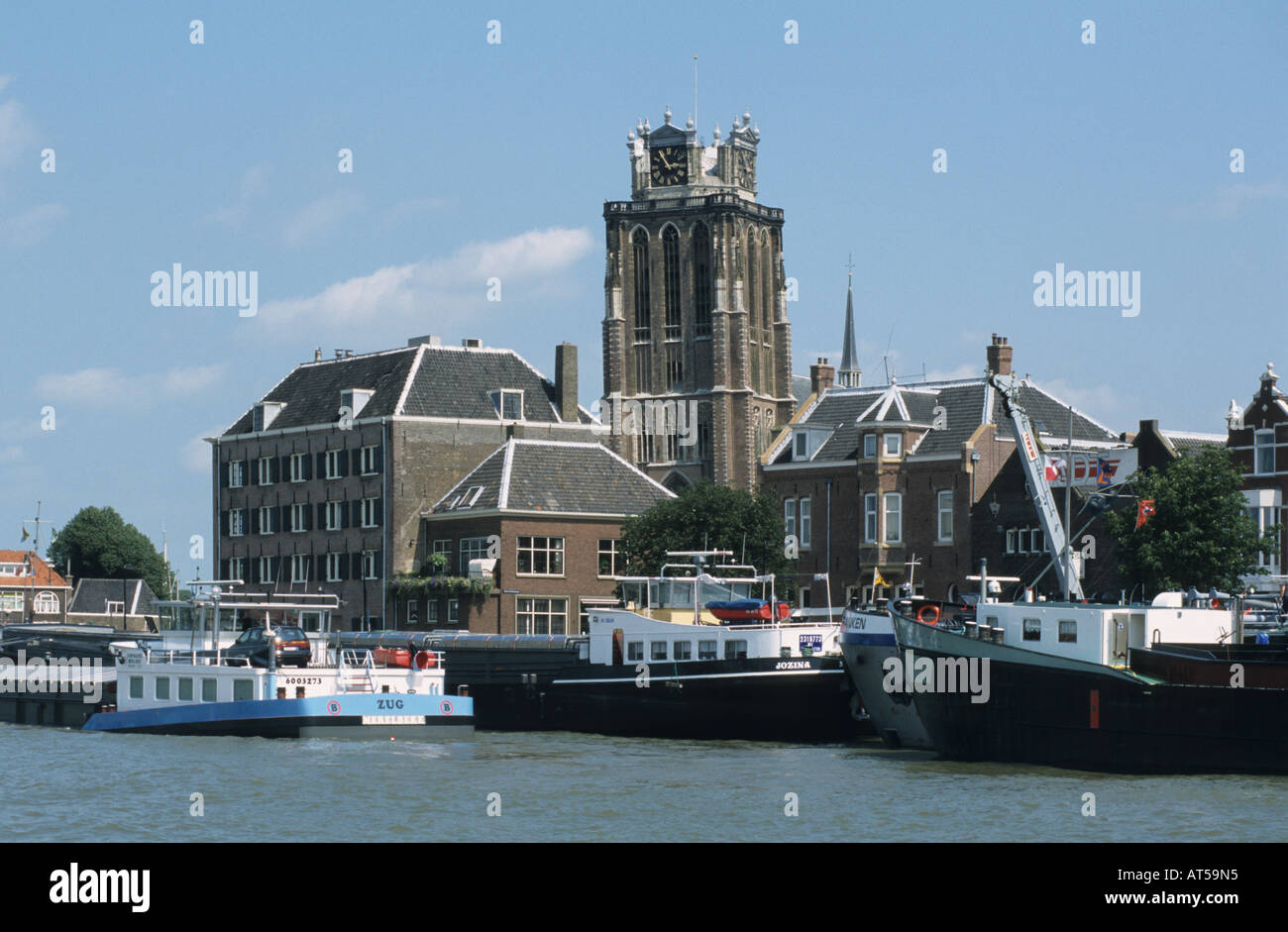 Boats docked along Dordrecht's canal with shops and cafes