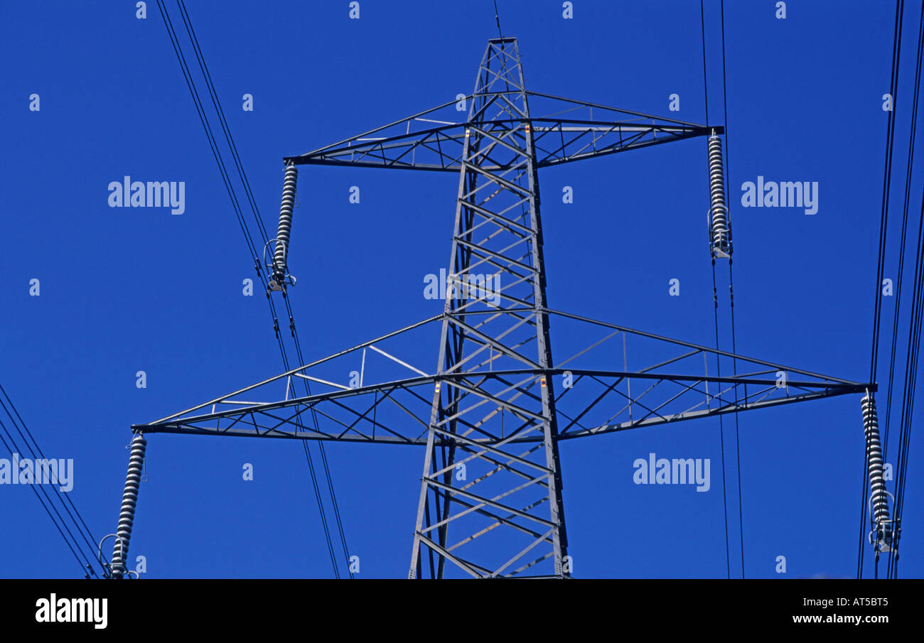 Electricity pylon transmission cable lines against blue sky Stock Photo