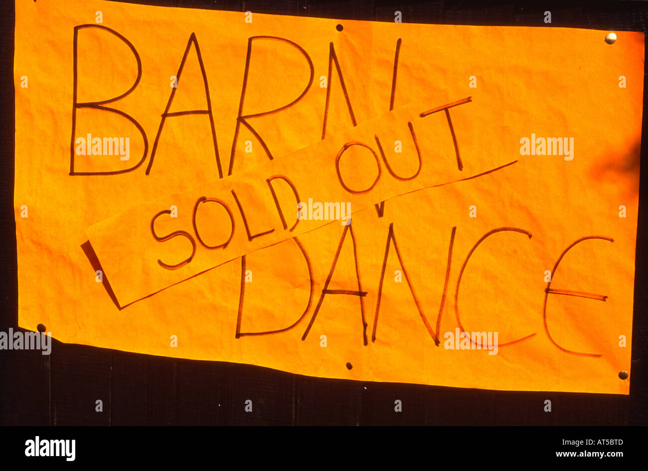 Orange paper sign with handwritten message saying Barn Dance Sold Out Stock Photo