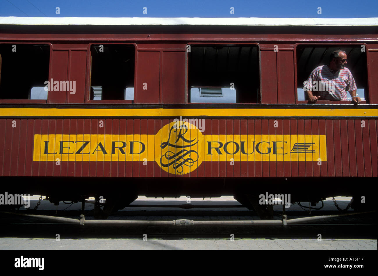 Passenger looking out the train window of the Le Lezard Rouge train which is an old French train turned into a tourist train Stock Photo