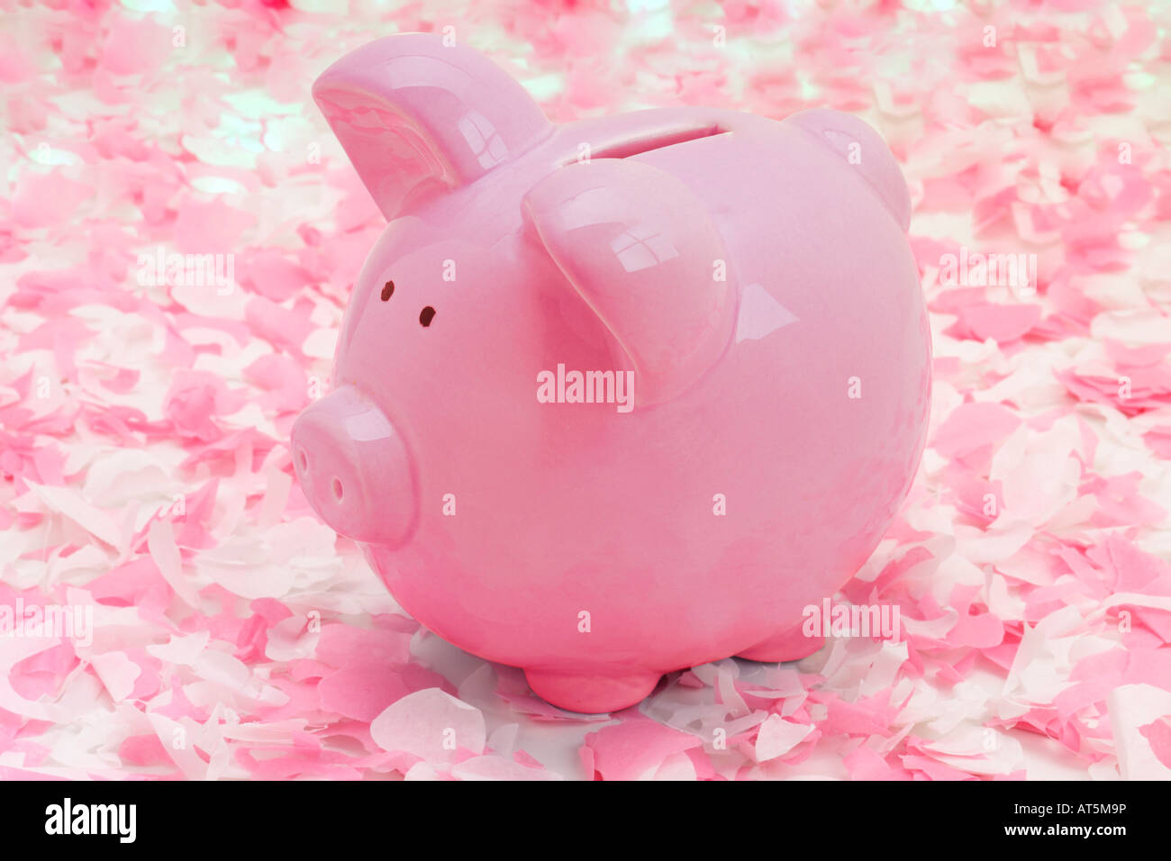 Pink piggy bank on pink confetti background Stock Photo - Alamy