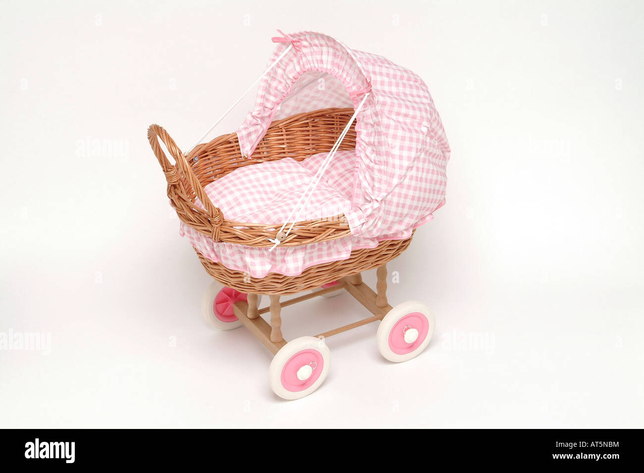 Wicker doll's pram with pink gingham covers Stock Photo