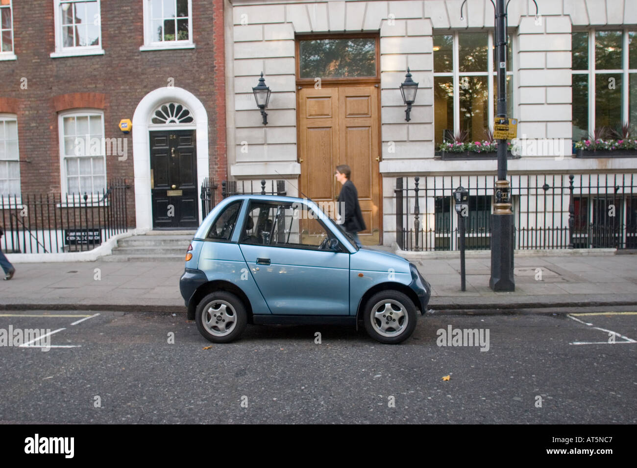 REVA electric car takes up only half a parking meter space landscape L Stock Photo