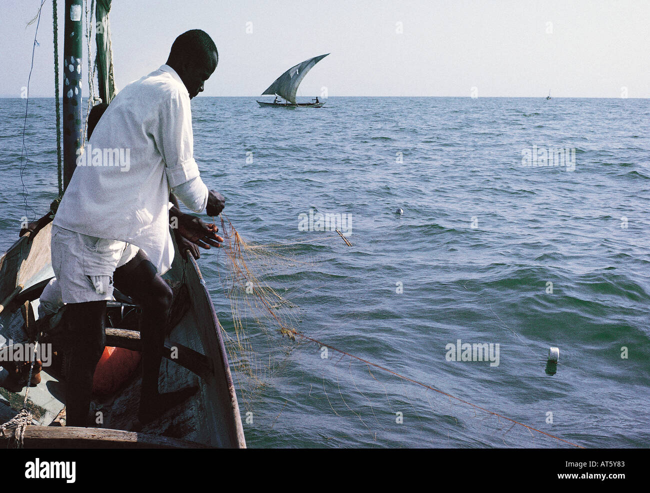 Luo fisherman checking his gill net from his sailing canoe Lake Victoria Kenya East Africa Stock Photo