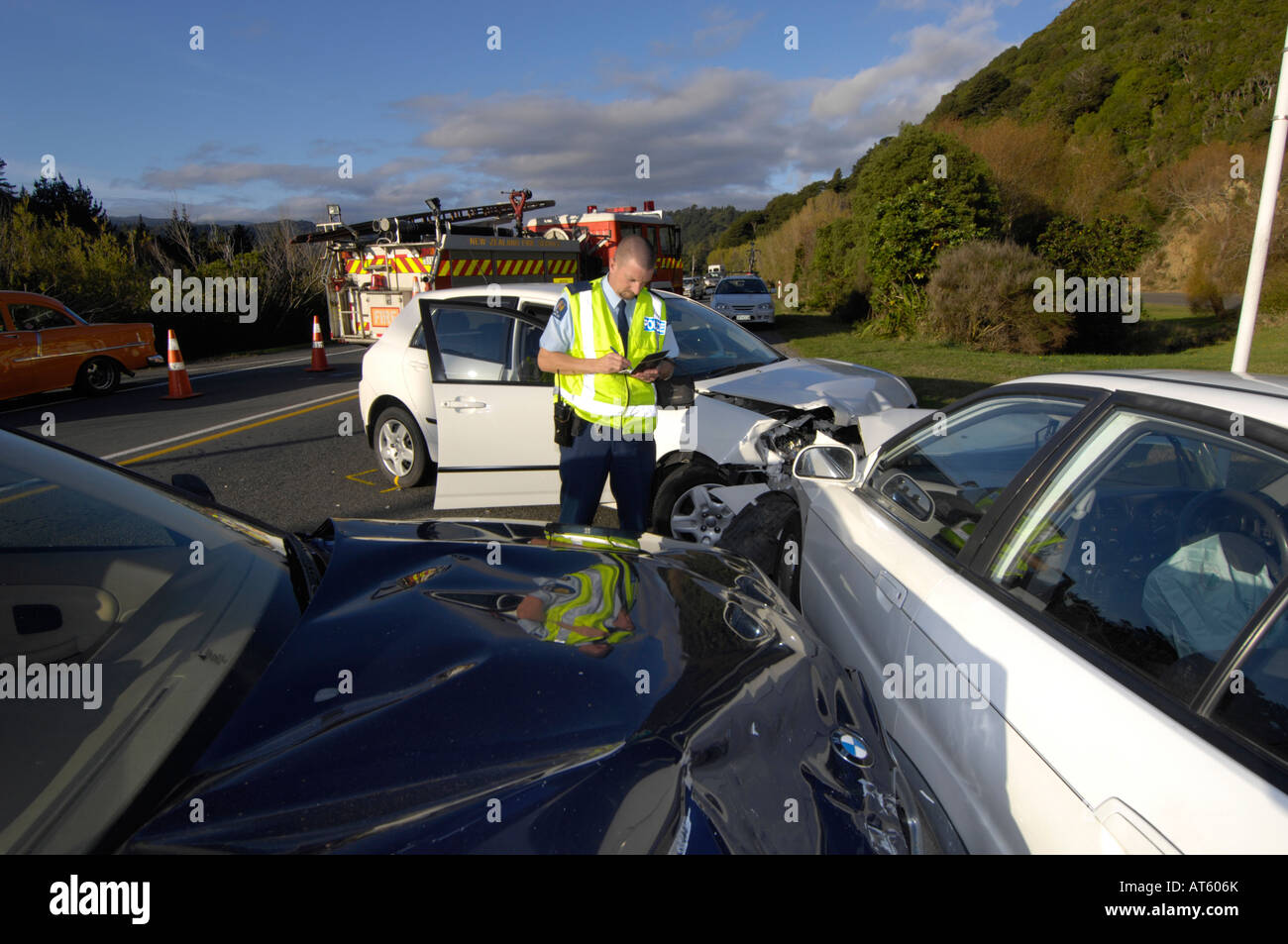 Police officer taking details of a car accident on the highway, Wellington, New Zealand Stock Photo