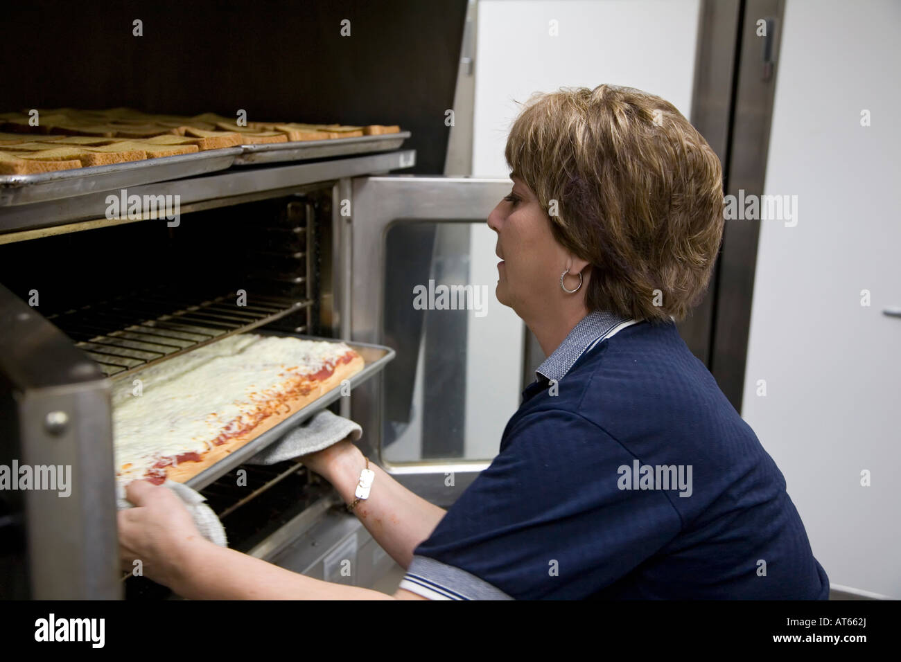 Dearborn Michigan Nancy Pizzini bakes pizza in the cafeteria at Miller Elementary School Stock Photo