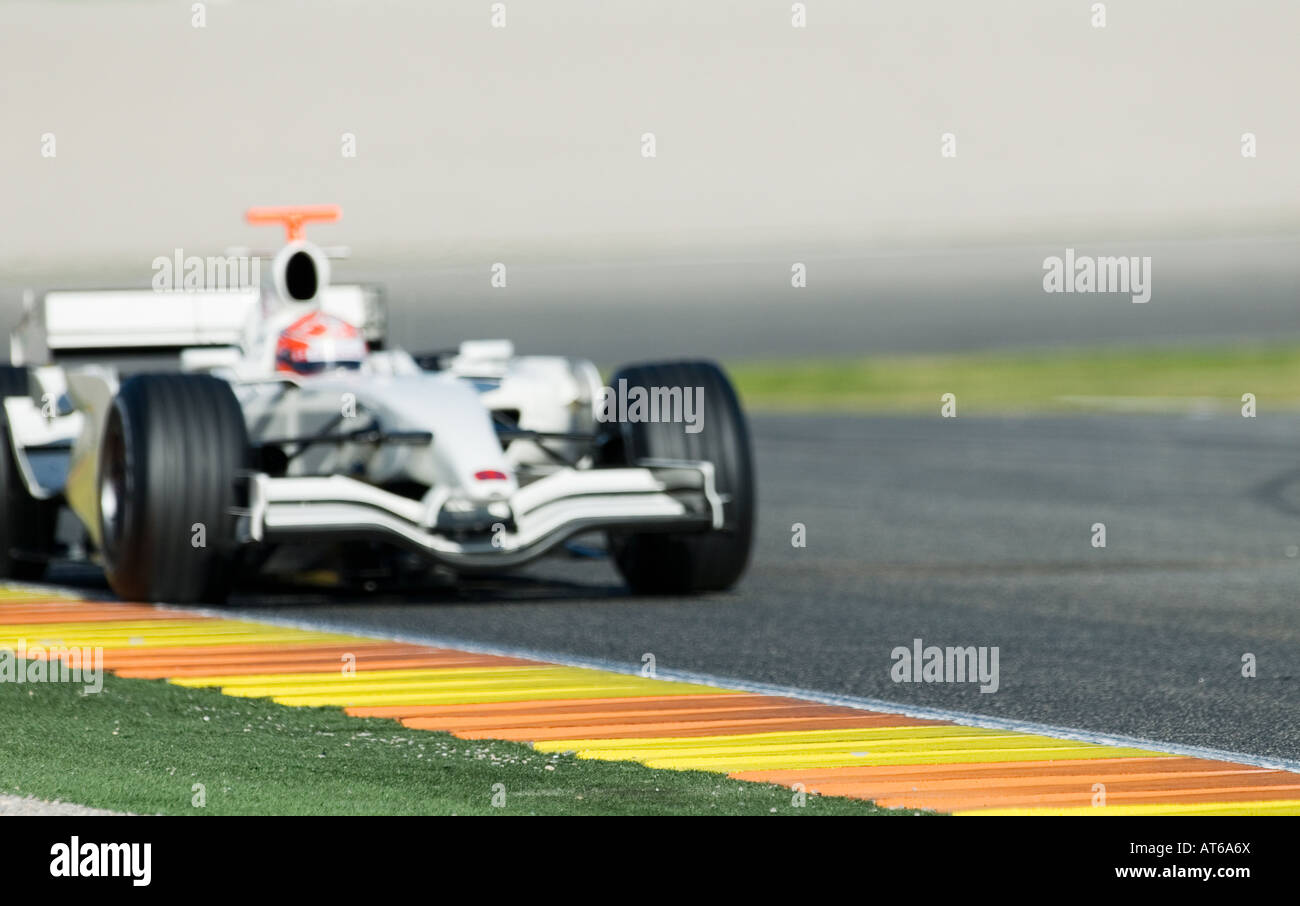 white Formula 1 racecar speeds through curve of racetrack INTENTIONAL ...