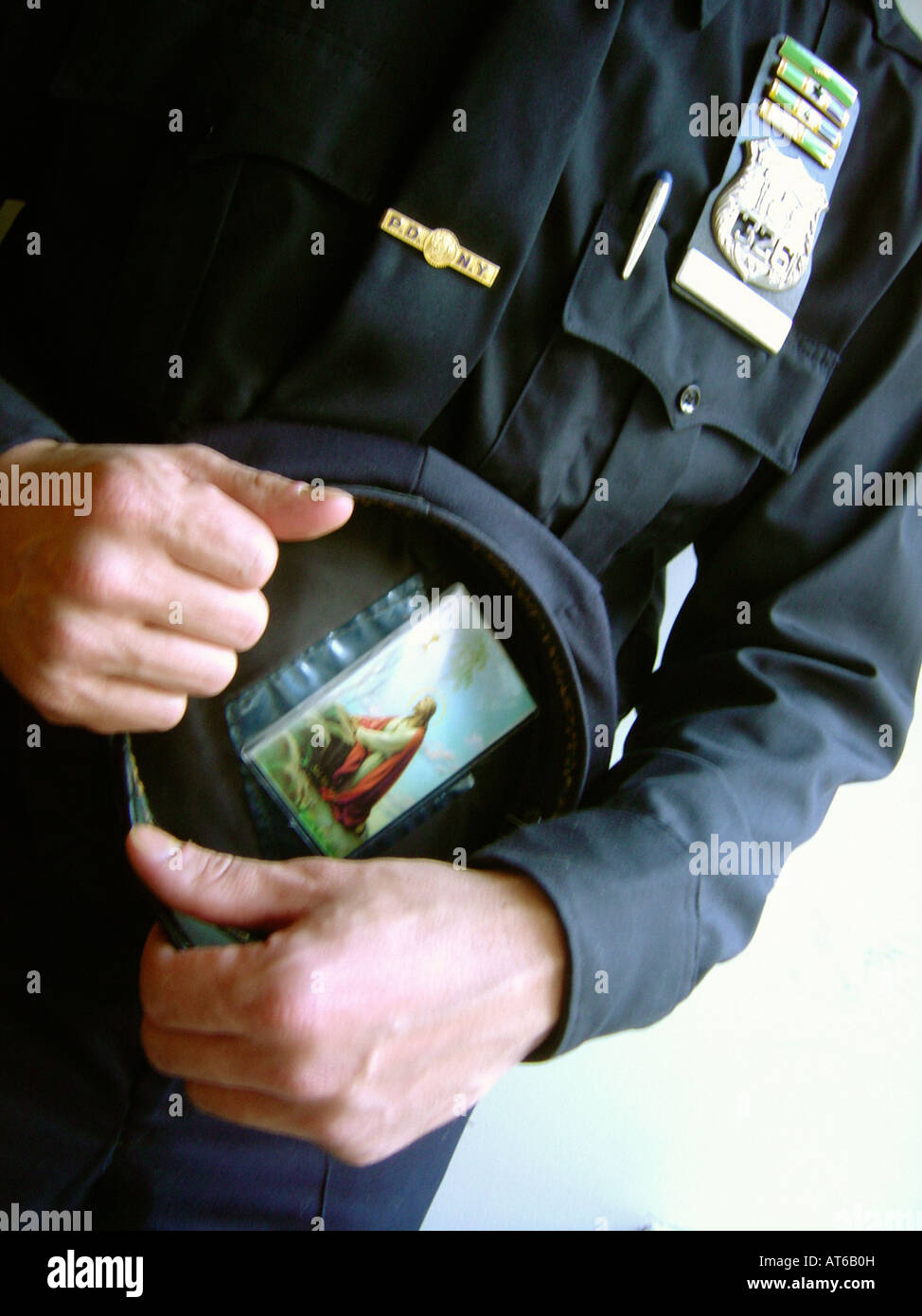 Artistic Portrait of a New York City Police Officer Holding His Hat Which Has a Prayer Card With An Image of Jesus Christ On It Stock Photo