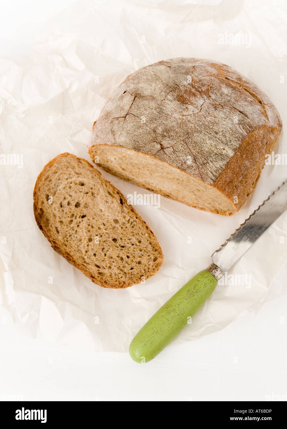 Organic wholemeal loaf of bread with a vintage bread knife Stock Photo