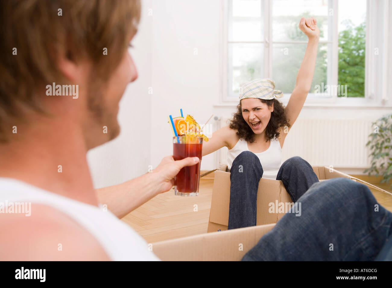 Couple, cheering woman in cardboard box Stock Photo - Alamy