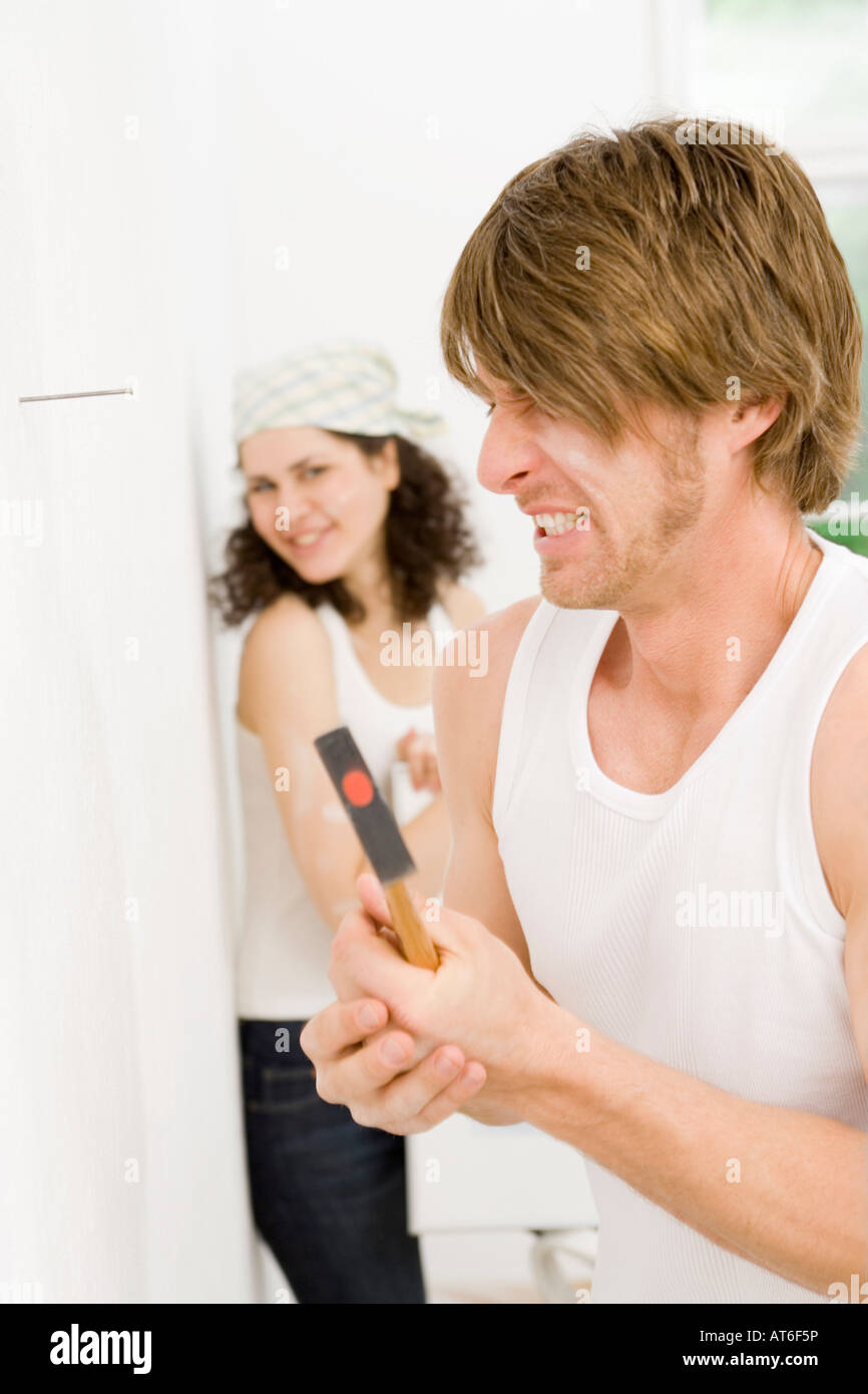 Young man hitting thumb with hammer, close-up Stock Photo