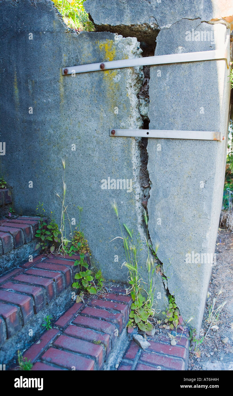 Cracked concrete retaining wall held together with steel bands Stock