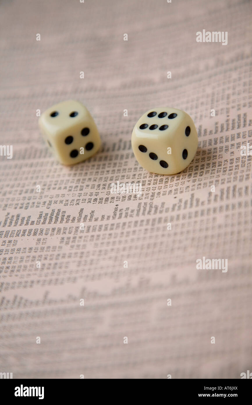 Pair of dice black and white thrown onto share listings in Financial Times Stock Photo