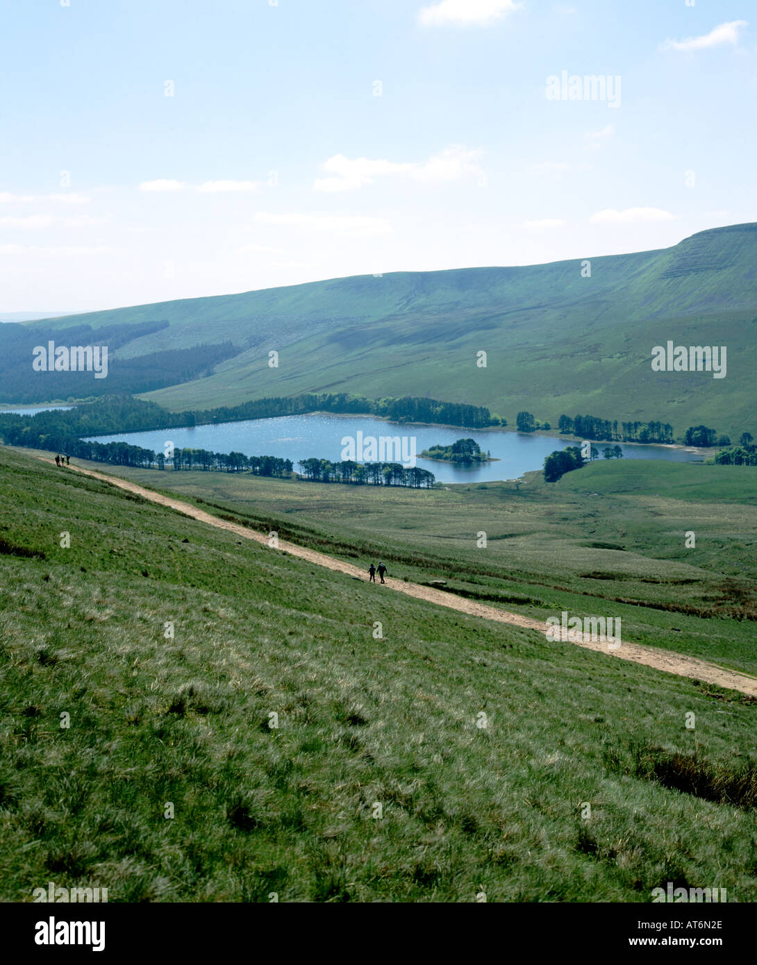 walkers on roman road with upper neuadd reservoir in the distance brecon beacons national park wales uk Stock Photo
