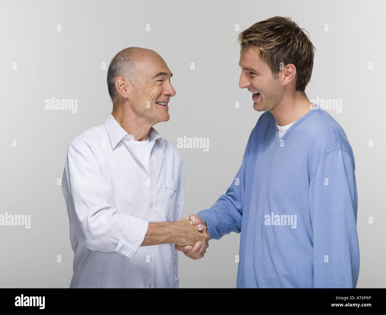 Senior man and young man shaking hands, portrait Stock Photo Alamy
