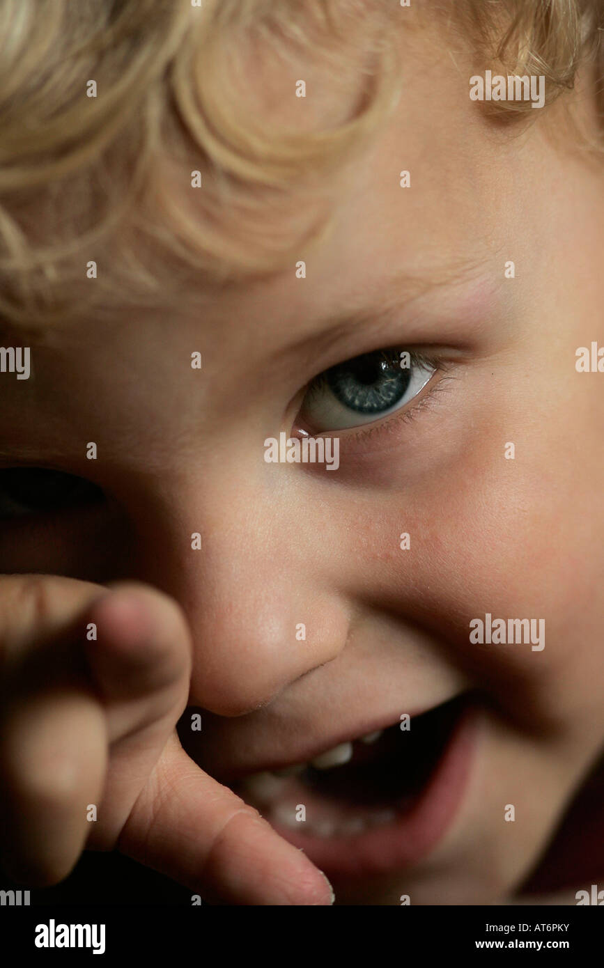 A two year old boy laughing and pointing at the camera Stock Photo