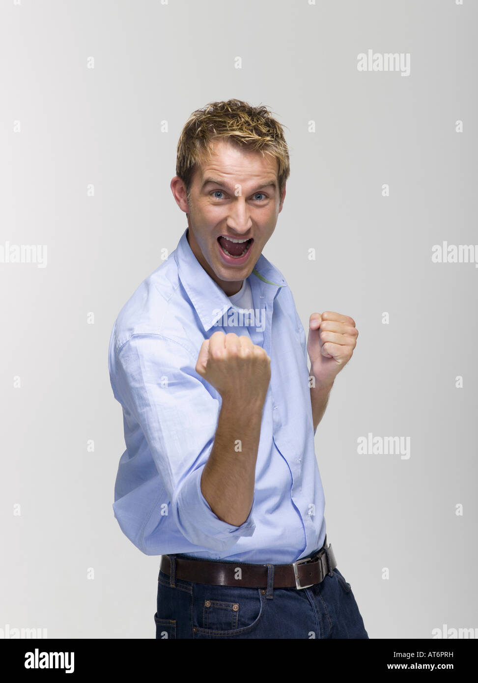 Young man smiling with clenched fist, portrait Stock Photo Alamy