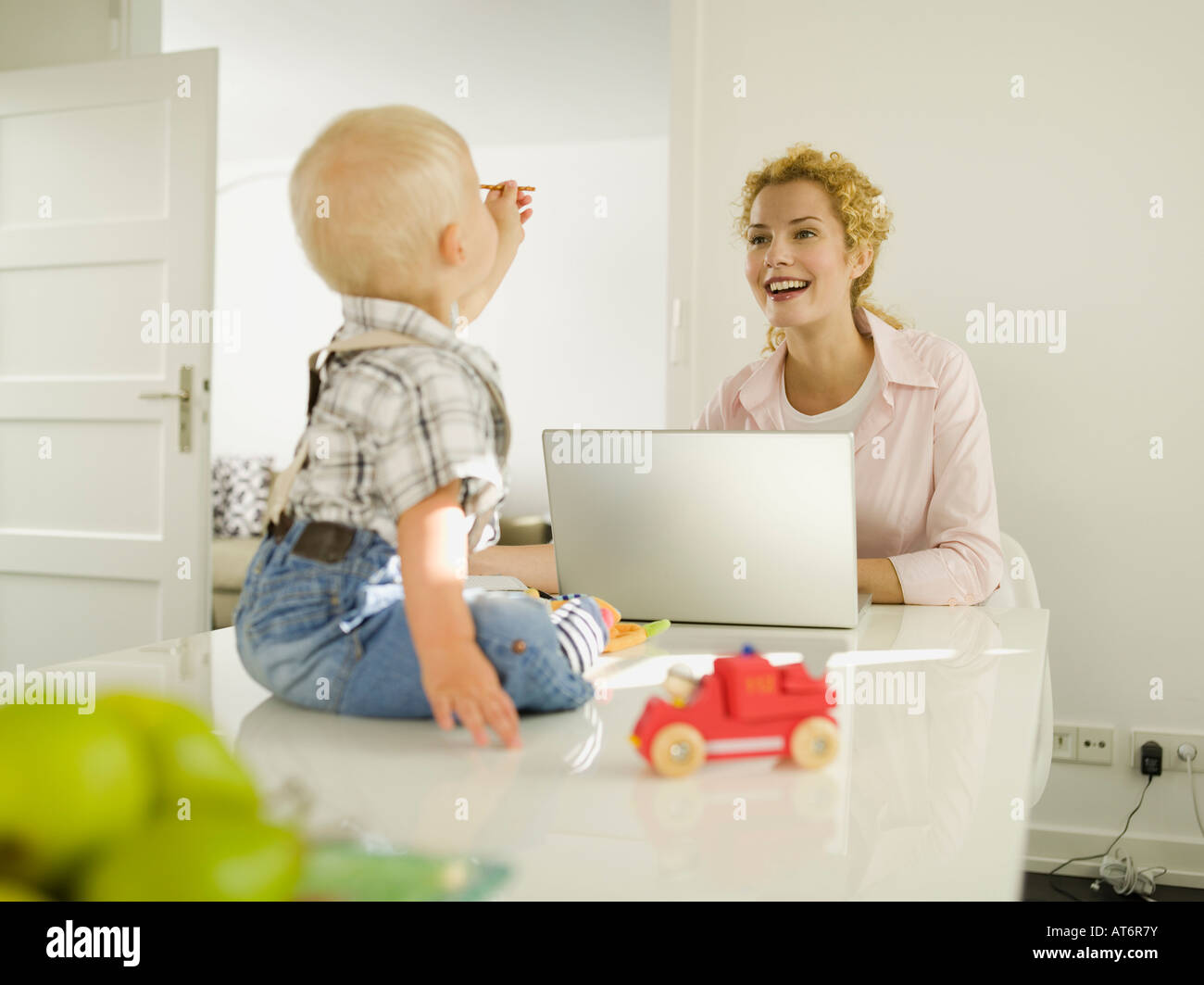 Mother and baby boy (12-24 months), mother using laptop Stock Photo
