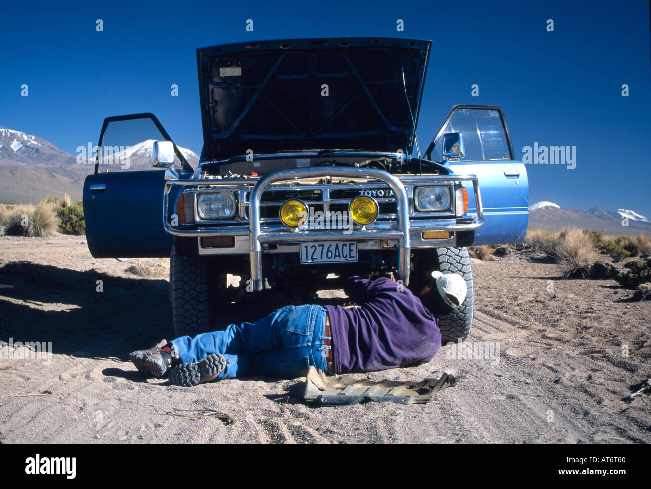 MAN FIXING CAR ON ROAD SIDE Stock Photo