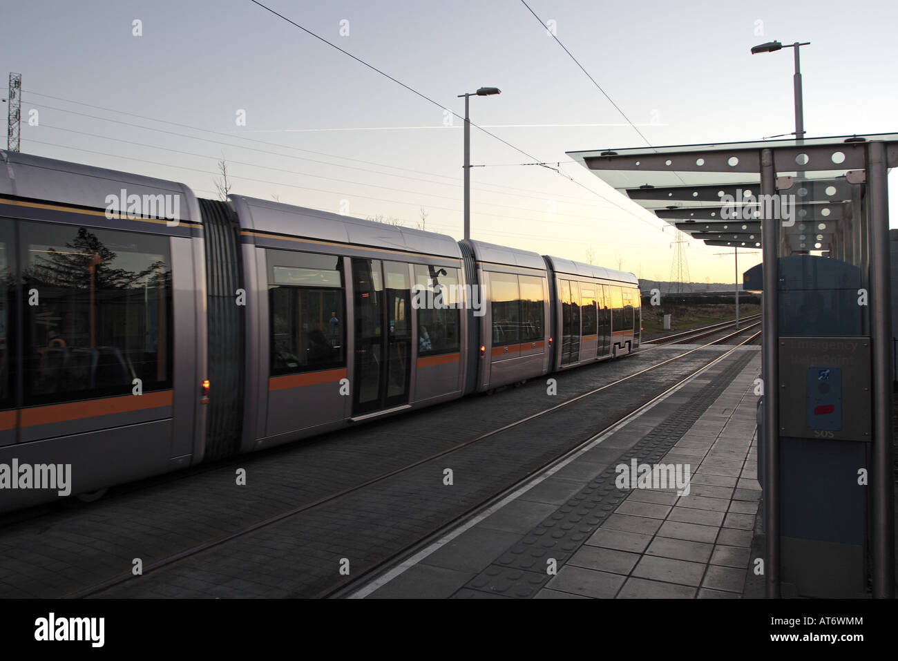 Tram pulling away from Belgard stop on the LUAS line public transport system in Dublin Ireland Stock Photo