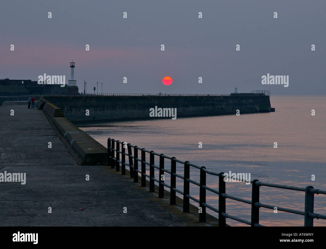 Sunset behind the harbour and pier, Maryport, Cumbria, England UK Stock Photo