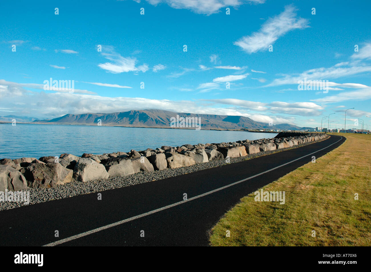 Cycle path along coastline with rocks and boulders in city of Reykjavik
