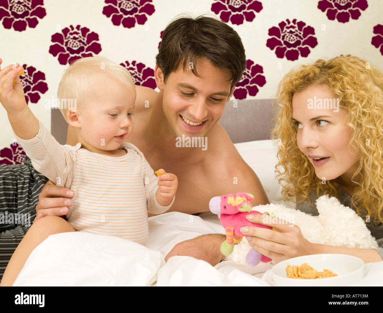 Parents With Baby Boy 12 24 Months In Bedroom Stock Photo