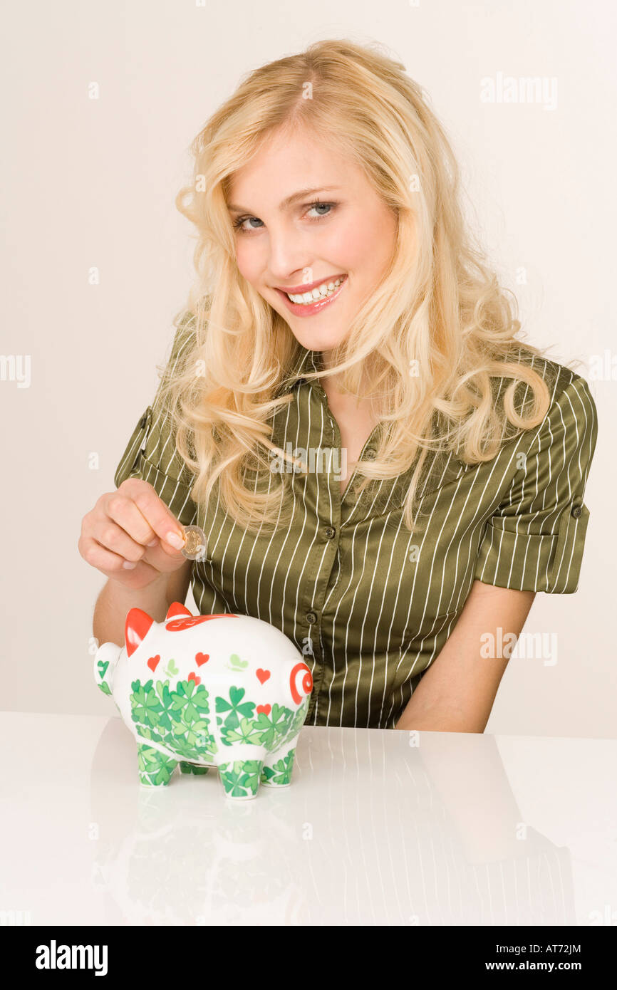 Blonde woman with piggy bank, portrait Stock Photo
