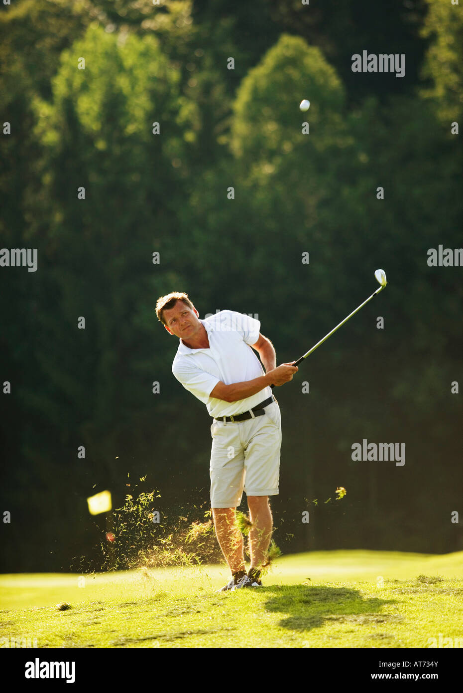 Austria, Male golfer swinging club on fairway Stock Photo