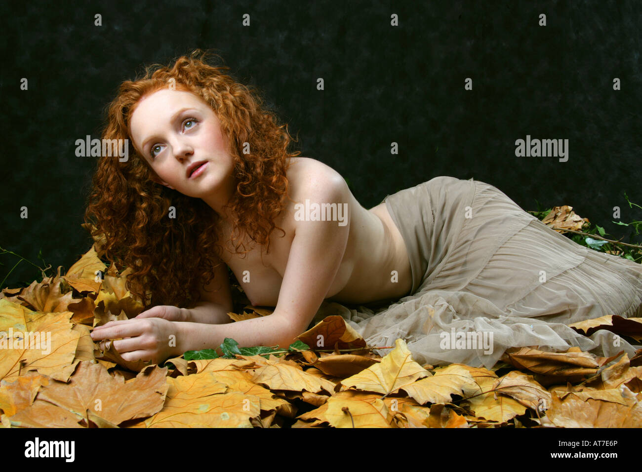 Art Nude Image - Semi Nude Red Haired Girl Laying on Leaves Stock Photo