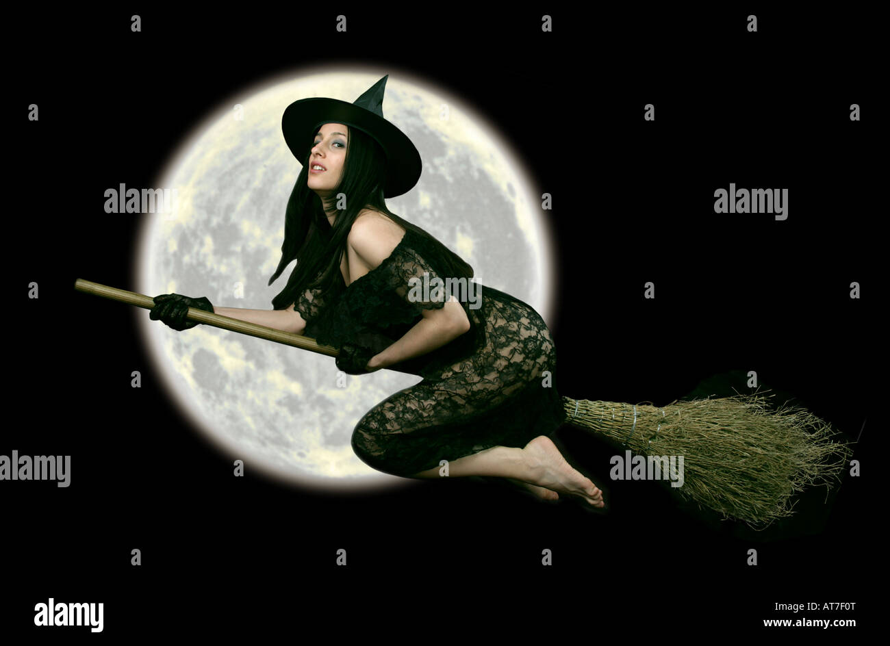 Fantasy Halloween Witch on a Broom Stick Flying Past the Moon Stock Photo