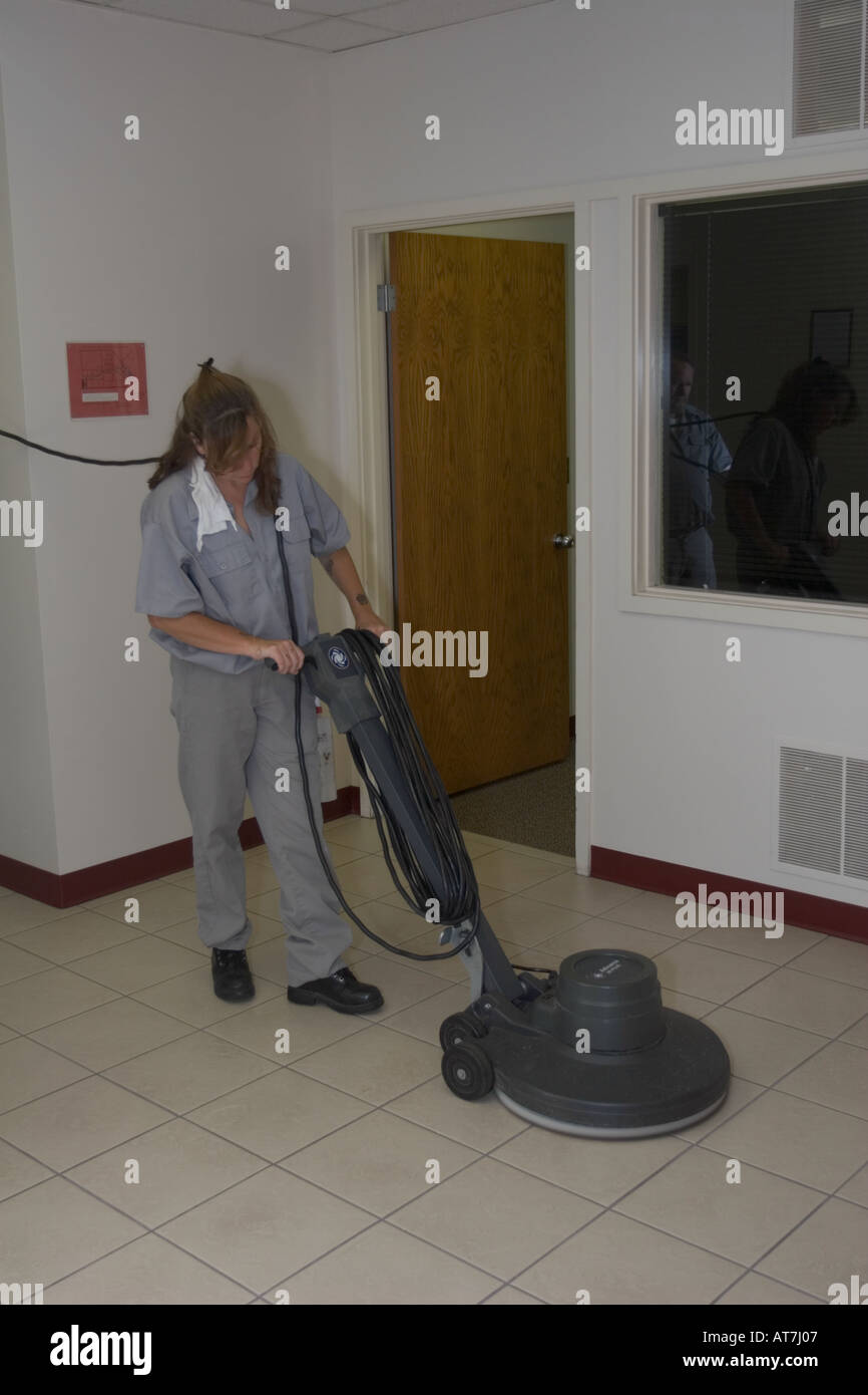 Female inmate waxing the floor in the administrative offices of the Nebraska State Penitentiary, Lincoln, Nebraska, USA. Stock Photo