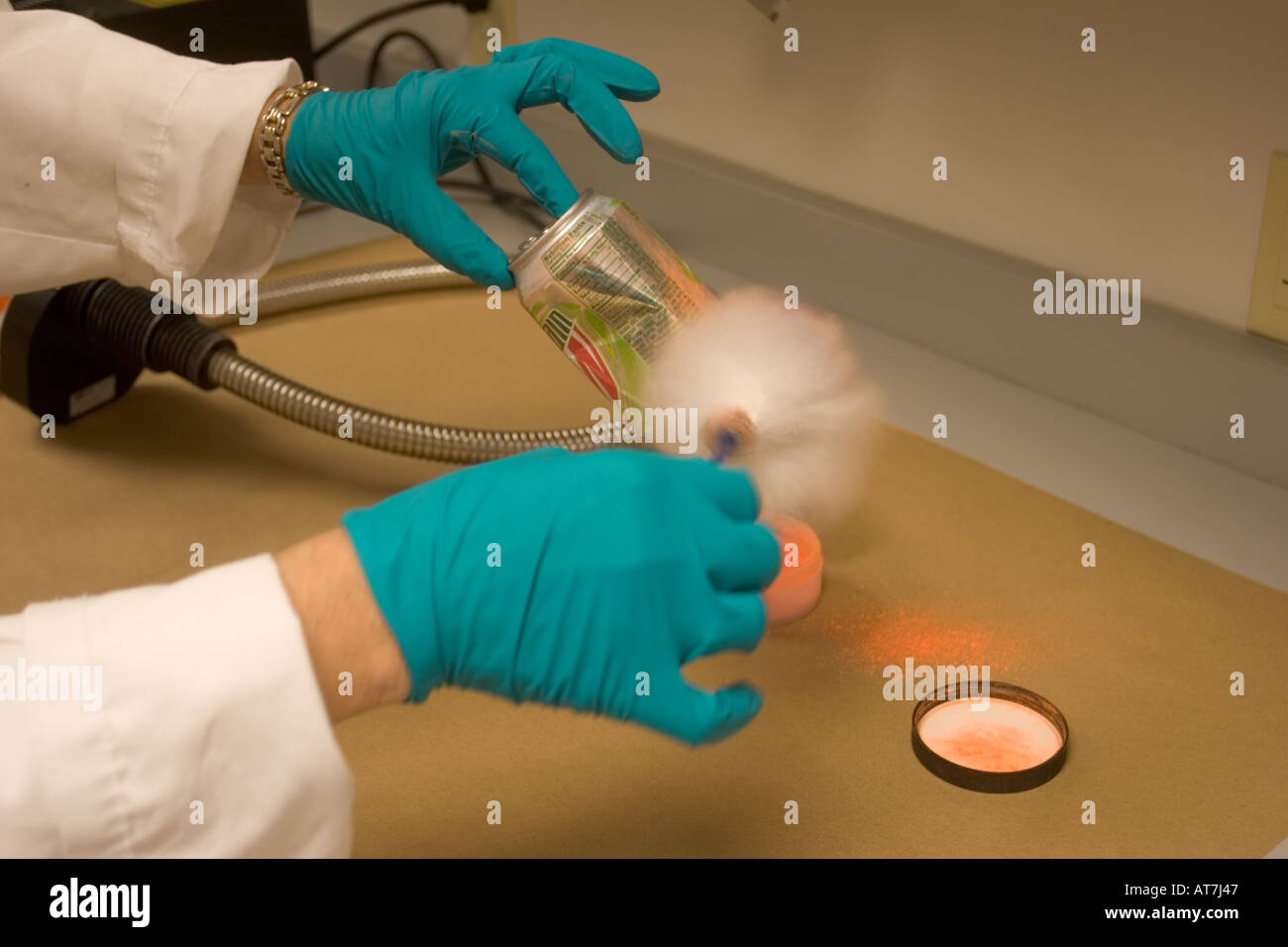 Latent print expert applying fluorescent fingerprint powder to a can