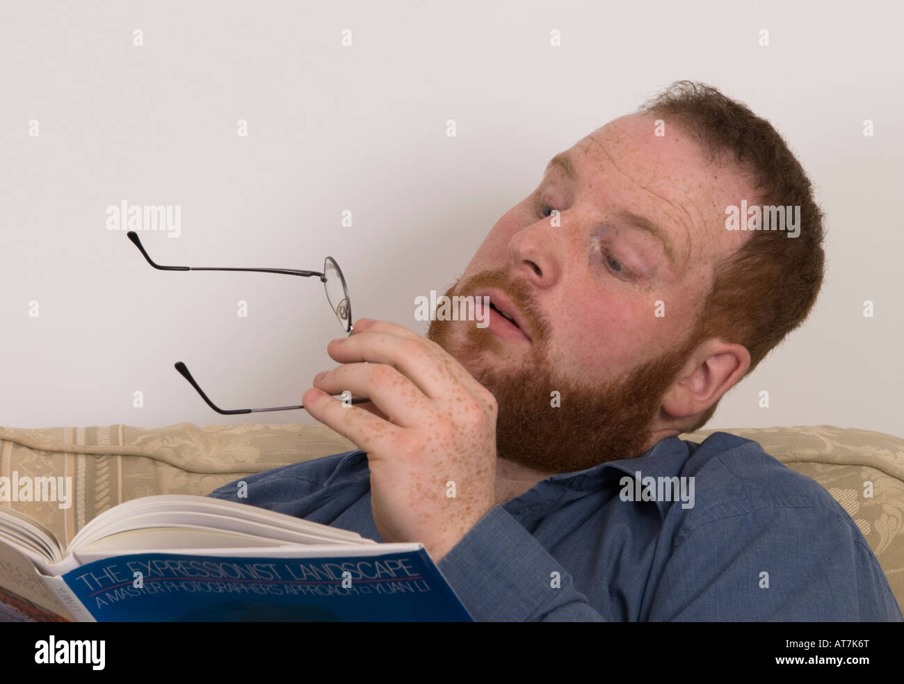 young man straining eyes after removing glasses, are they correct spectacles, correct prescription Stock Photo