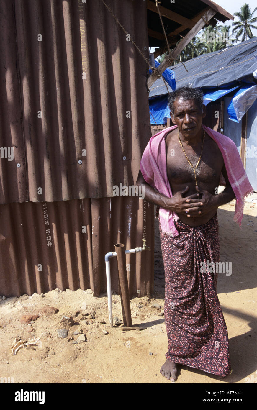 Man stands outside temporary shelter, tamil nadu, India. Stock Photo