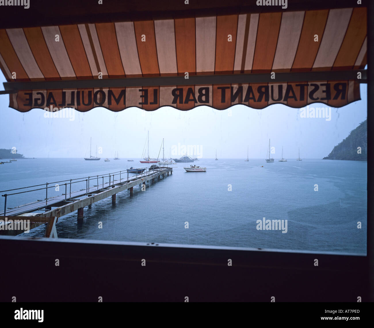 Landing stage and Deshaies harbour under rain, Guadeloupe, French West Indies Stock Photo