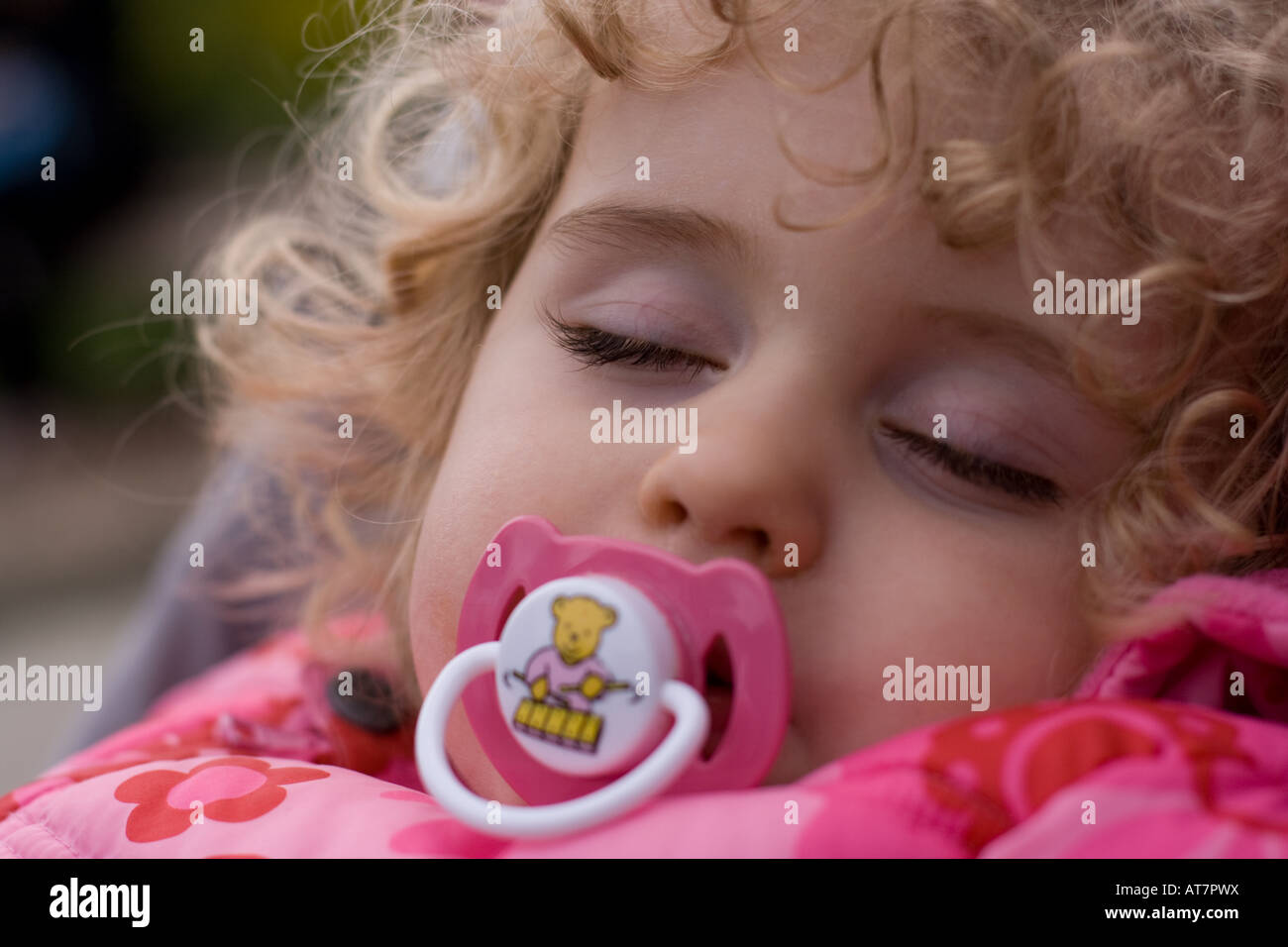 Little girl asleep in a pushchair with a dummy Stock Photo Alamy