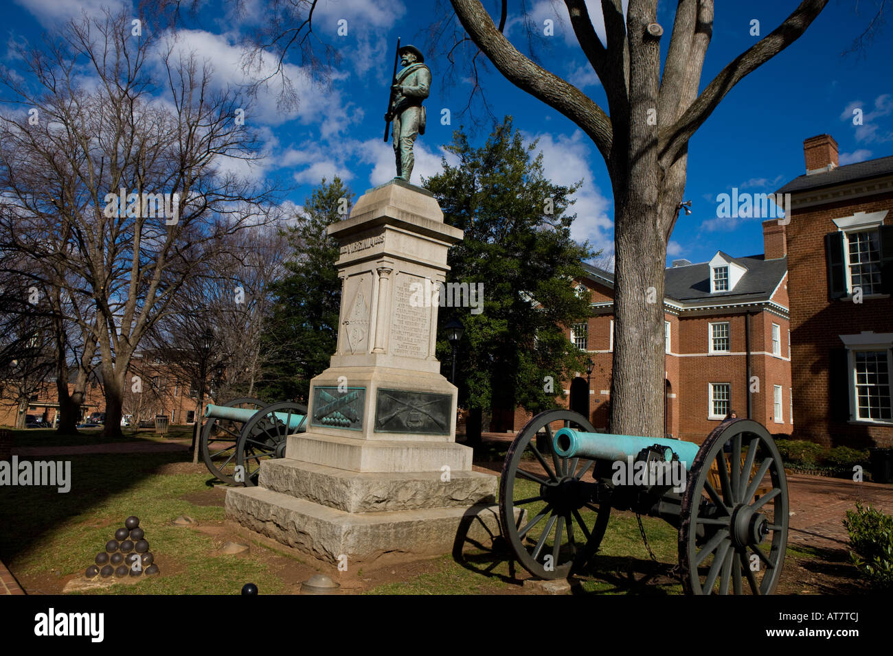 A statue of a Confederate soldier next to two Civil War era canons sits