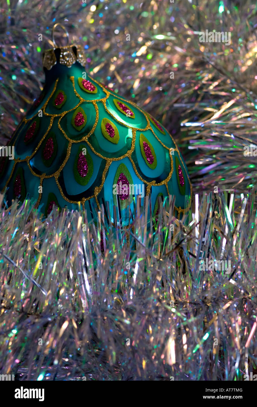 Turquoise and red christmas bauble surrounded with silver tinsel Stock Photo