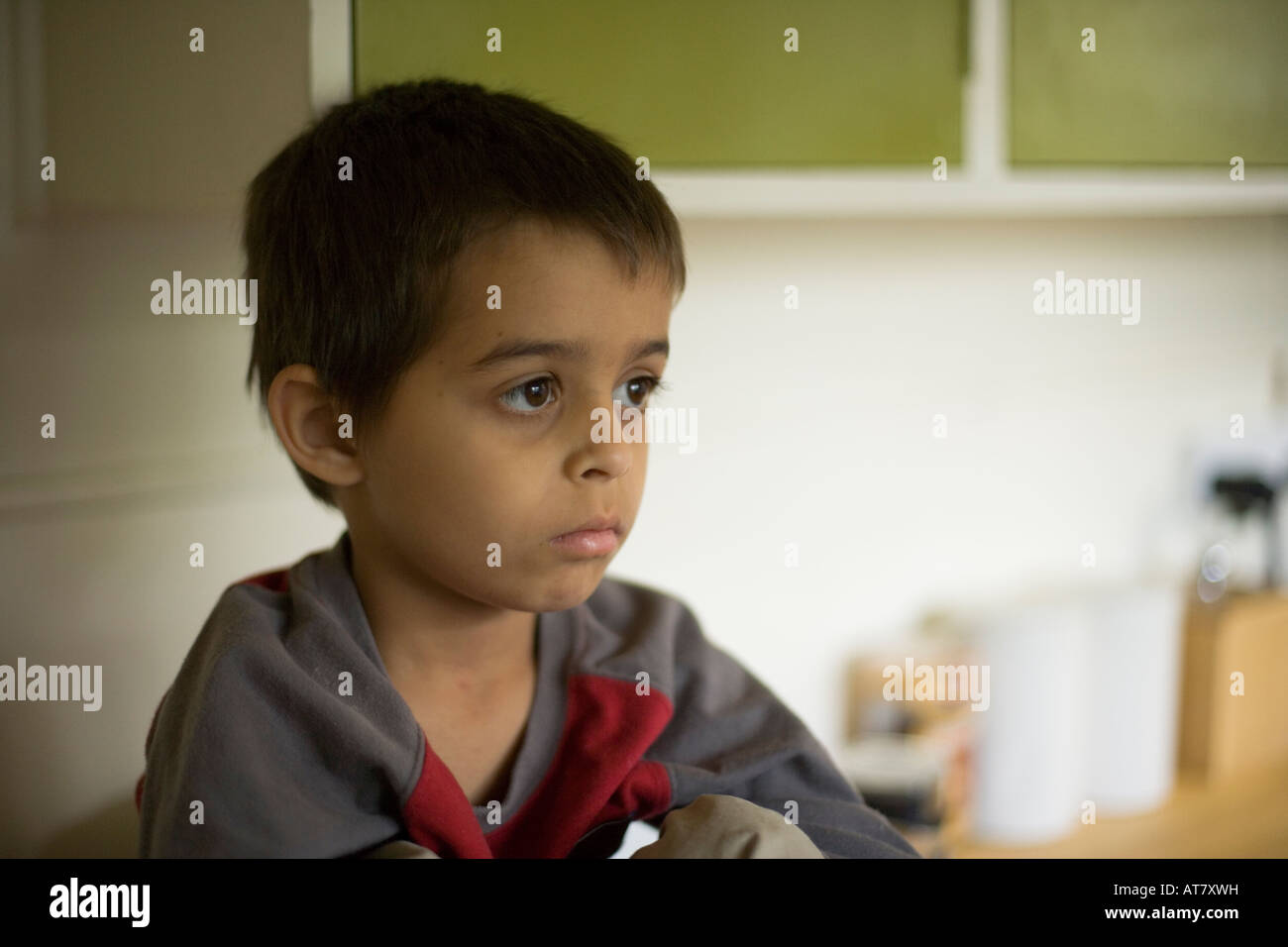 Enigmatic boy sits in the kitchen Stock Photo