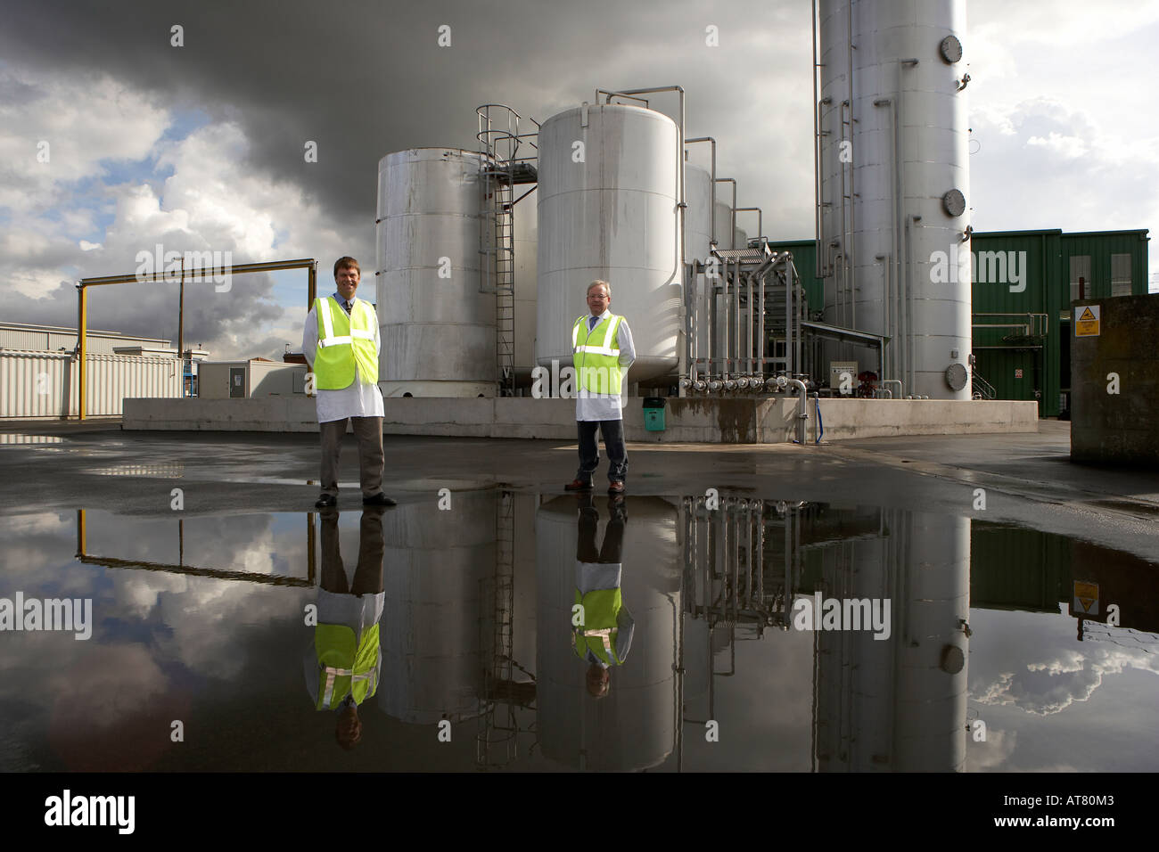 Two workers and reflections of a bulk liquid storage facility Goole East Yorkshire England UK