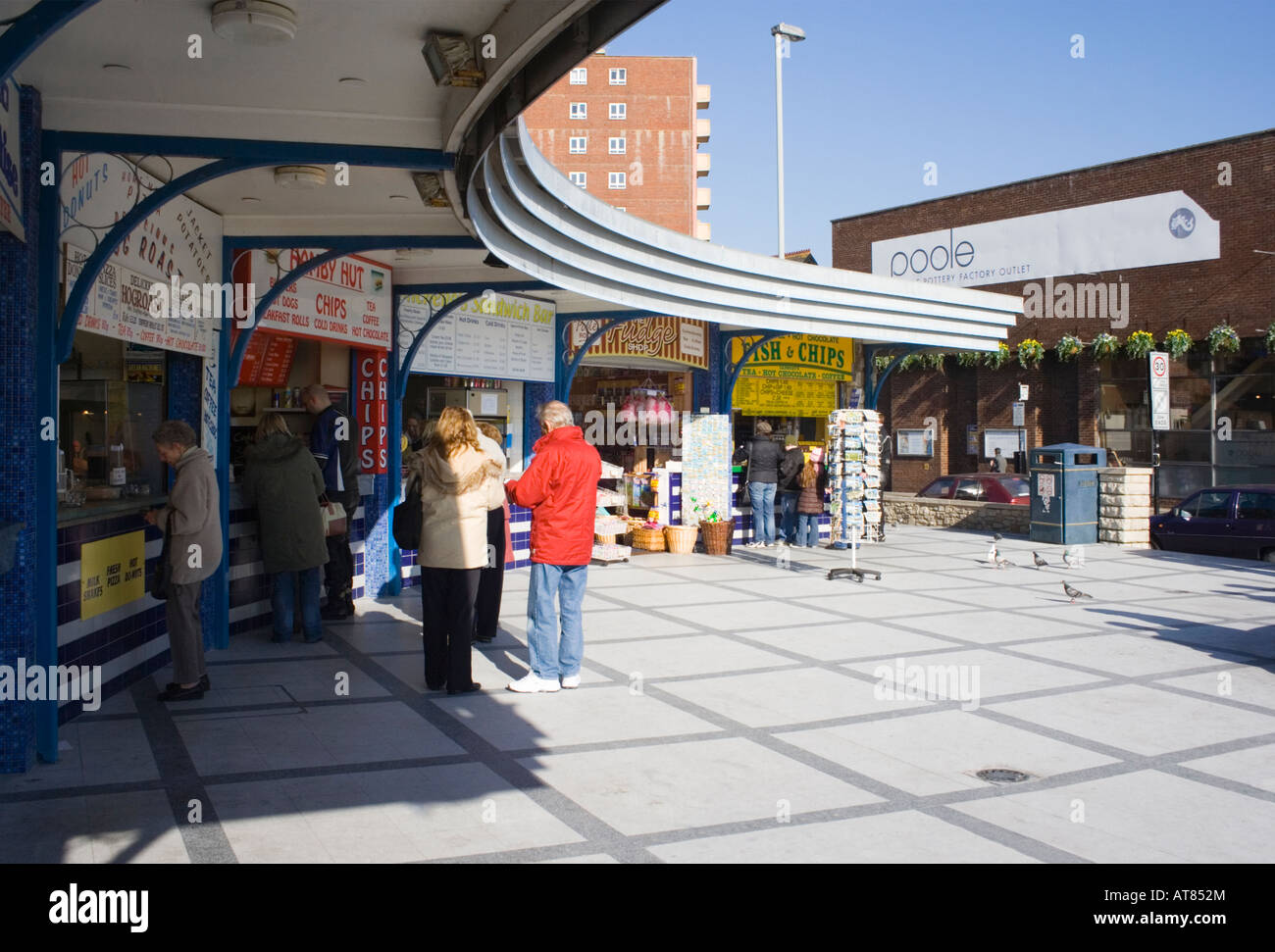 Fast food stalls and souvenir kiosks on Poole Quay. Dorset UK.  People enjoying early spring sunshine. Stock Photo