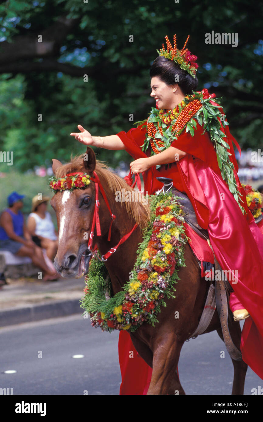 woman wearing flower leis and a traditional wrapped skirt, or pa'u, rides on horseback in the Aloha Festivals Parade Stock Photo