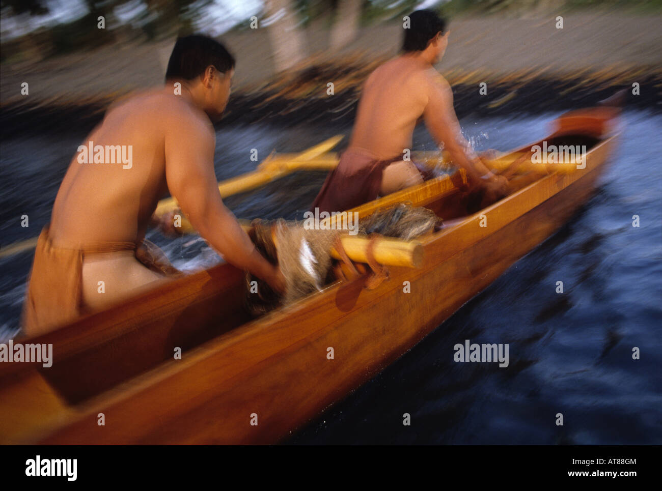 Traditional Hawaiian fishing canoe (made of acacia koa wood) being pulled ashore; Mauna Lani Resort, Hawaii. Stock Photo