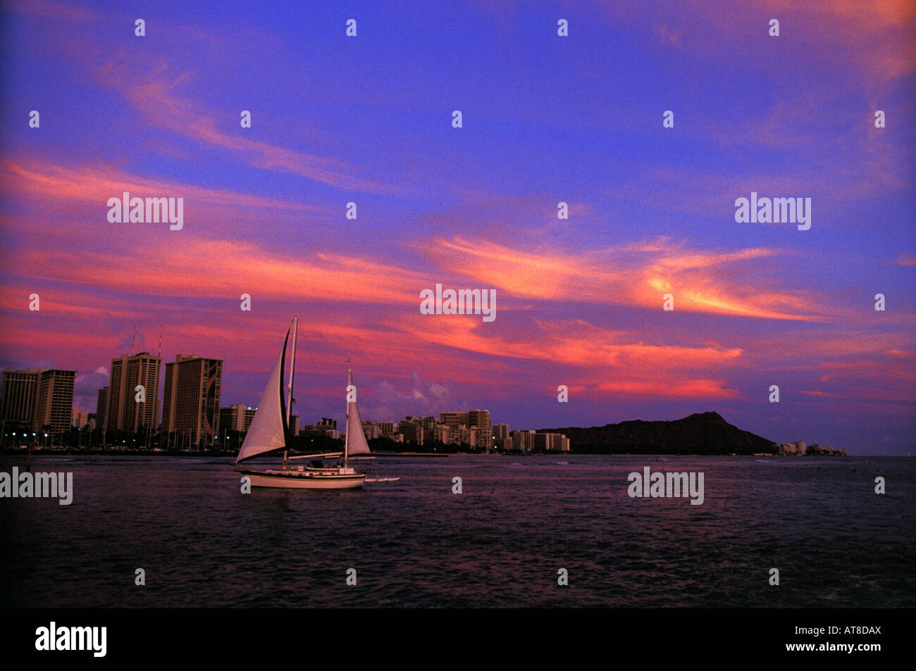 A beautiful sunset with Waikiki beach and Diamond head with with sail
