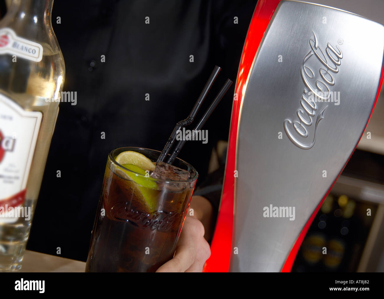 barperson serving a rum and coke drink Stock Photo