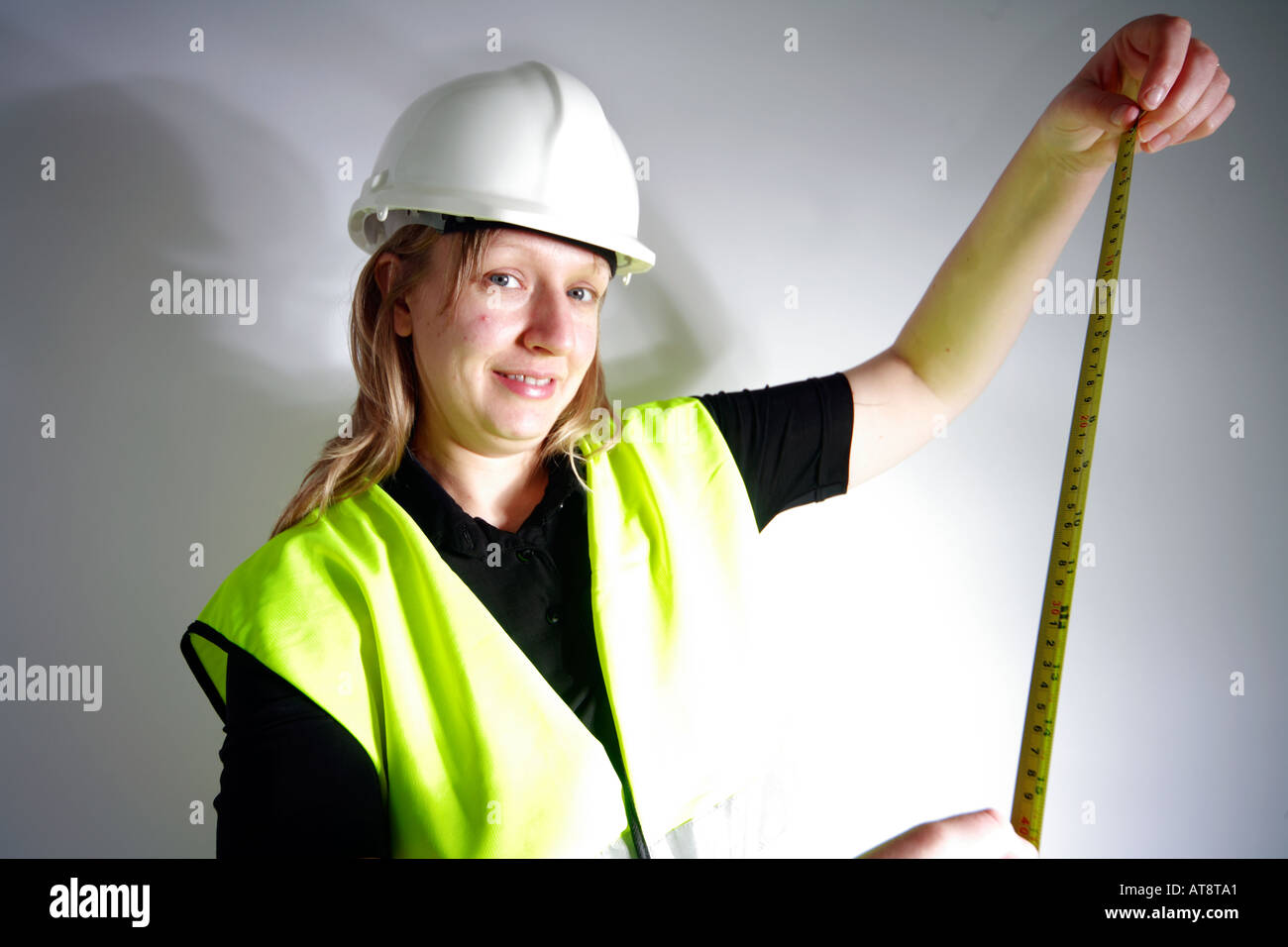 Female construction worker with measuring tape Stock Photo